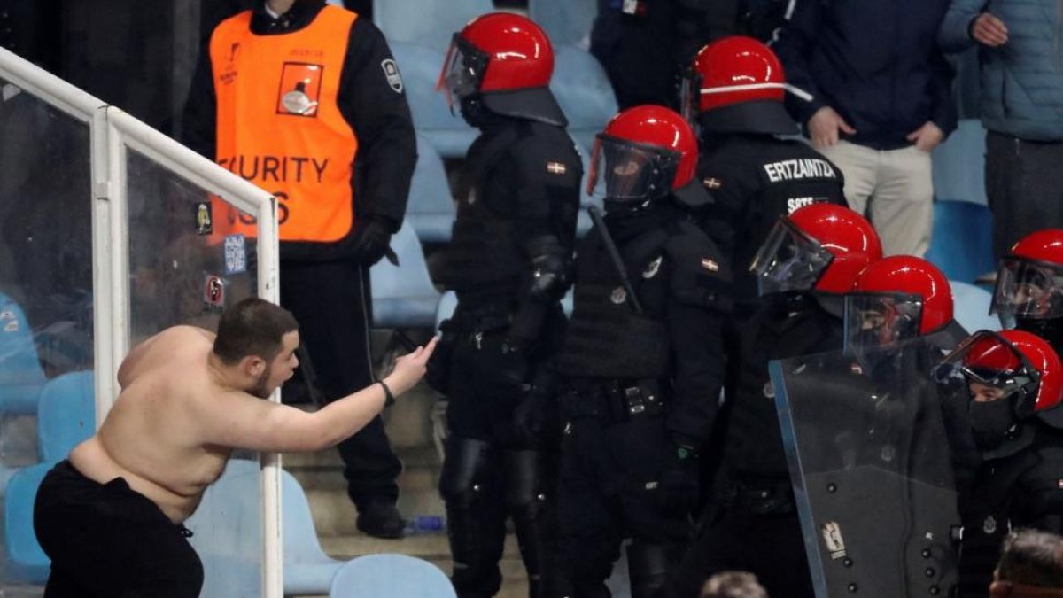 Un aficionado del Zenit San Petersurgo se encara con miembros de la Ertzaintza, durante el partido de la Liga Europa ante la Real Sociedad.-JAVIER ETXEZARRETA (EFE)