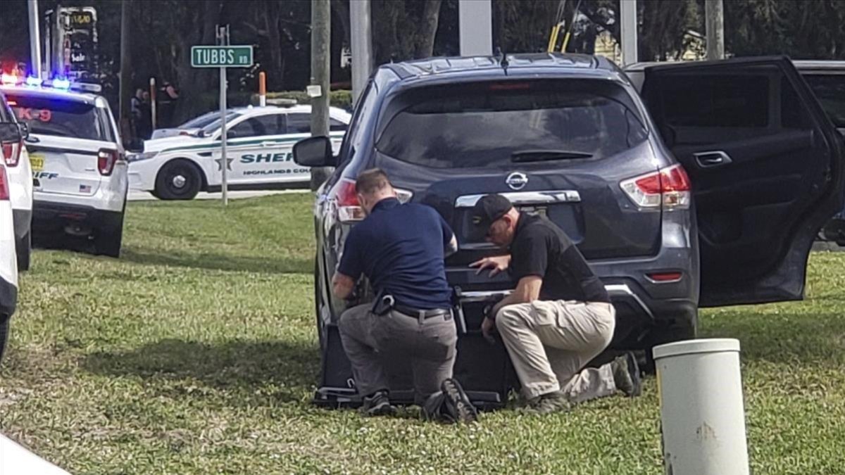 Agentes de policía se protegen tras su vehículo durante el tiroteo en el banco de Florida, este miércoles.-AP