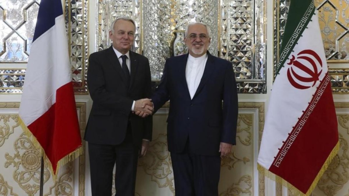 Zarif (derecha) estrecha la mano de su homólogo francés, Jean-Marc Ayrault, antes de su encuentro en Teherán, este martes.-AP / VAHID SALEMI