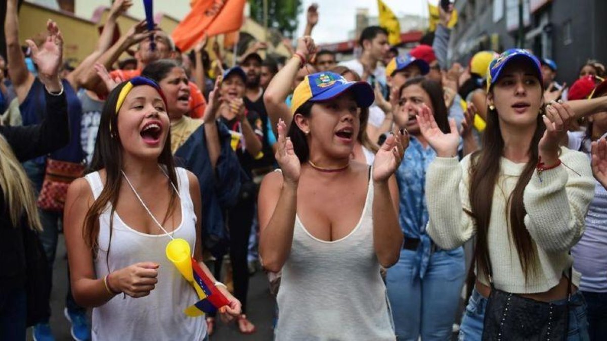 Varias jóvenes gritan consignas contra el presidente Maduro, en Los Teques (Estado de Miranda, Venezuela).-AFP / RONALDO SCHEMIDT