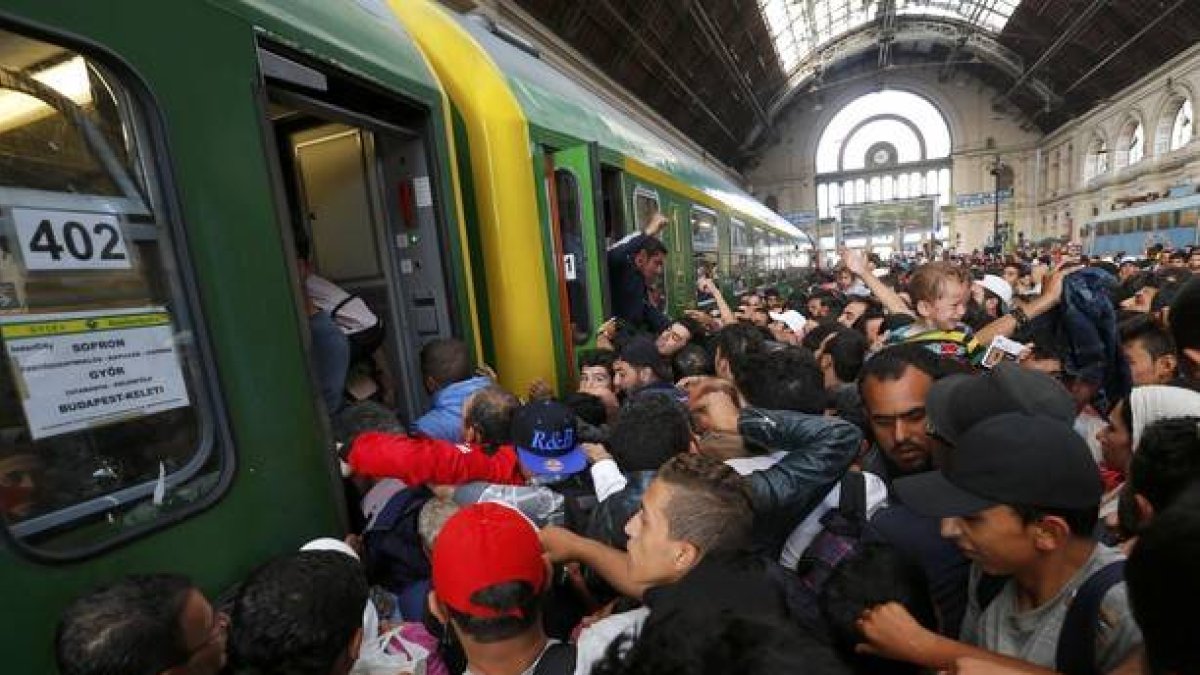 Los cientos de inmigrantes que han esperado durante dos días la reapertura de la estación de Keleti suben masivamente al primer tren.-REUTERS