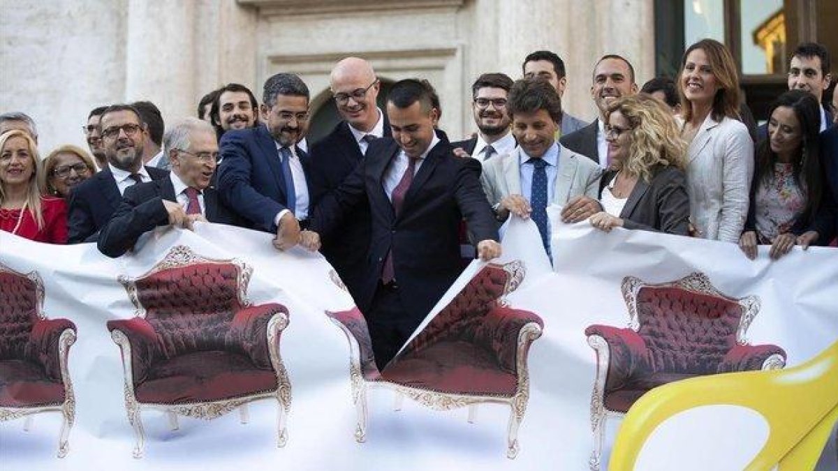 Di Maio (centro) y otros políticos rasgan una pancarta ilustrativa sobre la reforma para reducir el número de parlamentarios en Italia.-MASSIMO PERCOSSI (EFE)