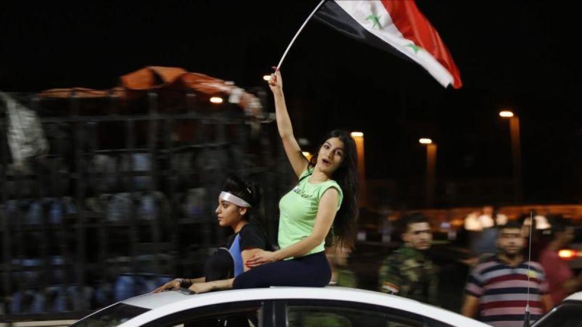 Aficionados sirios celebran el empate ante Irán.-AFP / LOUAI BESHARA