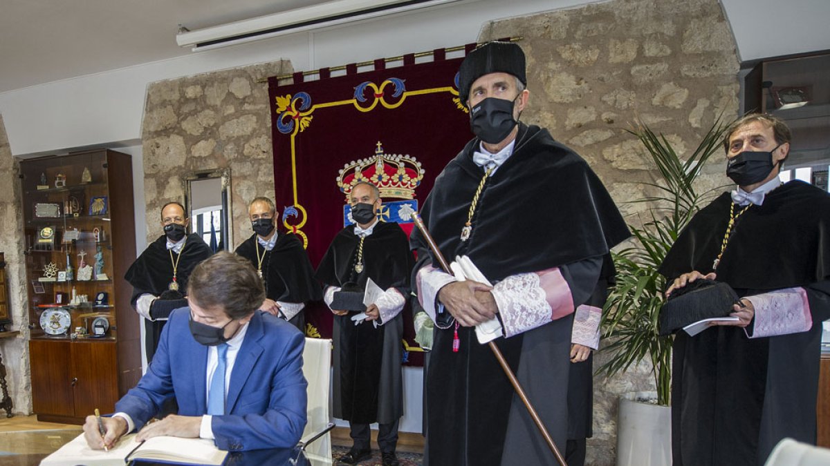 El presidente de la Junta firma en el libro de la UBU, flanqueado por los rectores de Castilla y León. ISRAEL L. MURILLO