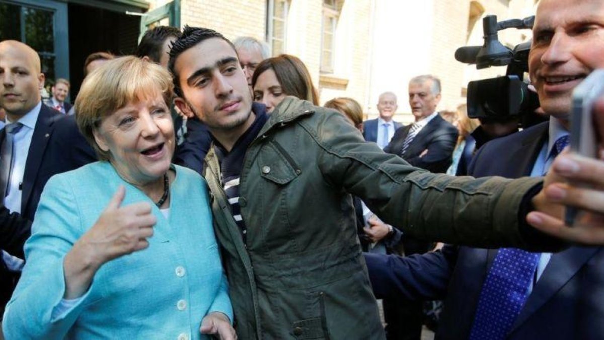 El refugiado sirio Anas M. se hace un selfie con Merkel, en septiembre del 2015.-REUTERS / FABRIZIO BENSCH