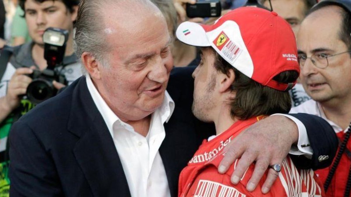 El Rey Juan Carlos consuela a Fernando Alonso, en el GP de Abu Dabi del 2010.-AP / GERO BRELOER