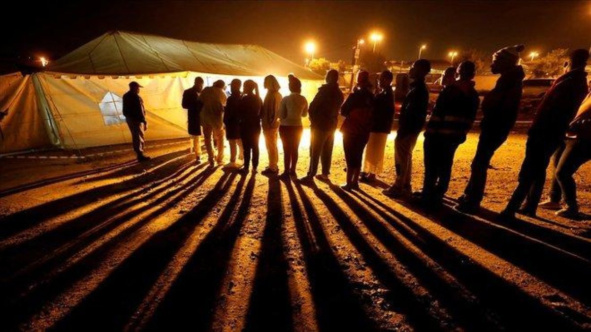 Votantes hacen cola frente a un local electoral antes del cierre de la votación, este miércoles en Johannesburgo.-MIKE HUTCHINGS (REUTERS)