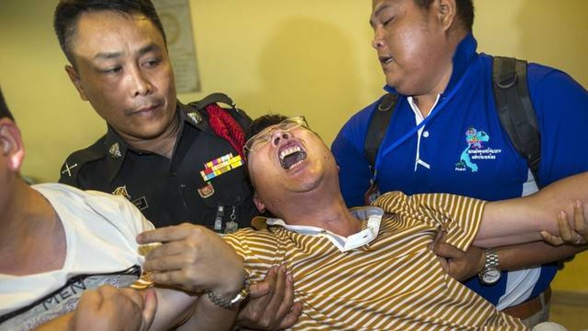 Un ciudadano chino que perdió a su mujer y a su hija en el atentado llora desconsolado en el Instituto de Medicina Forense de Bangkok.-Foto: REUTERS / ATHIT PERAWONGMETHA