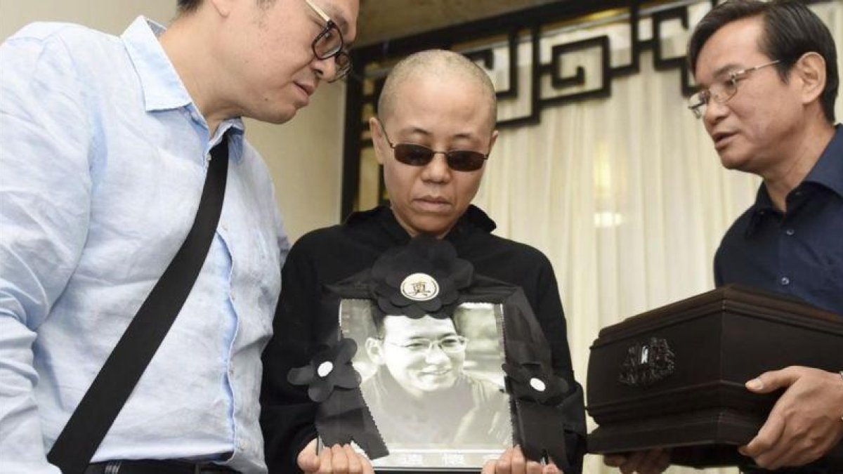 Liu Xia, esposa del premio Nobel de la Paz fallecido Liu Xiaobo, muestra una foto de su marido en día del funeral.-AP