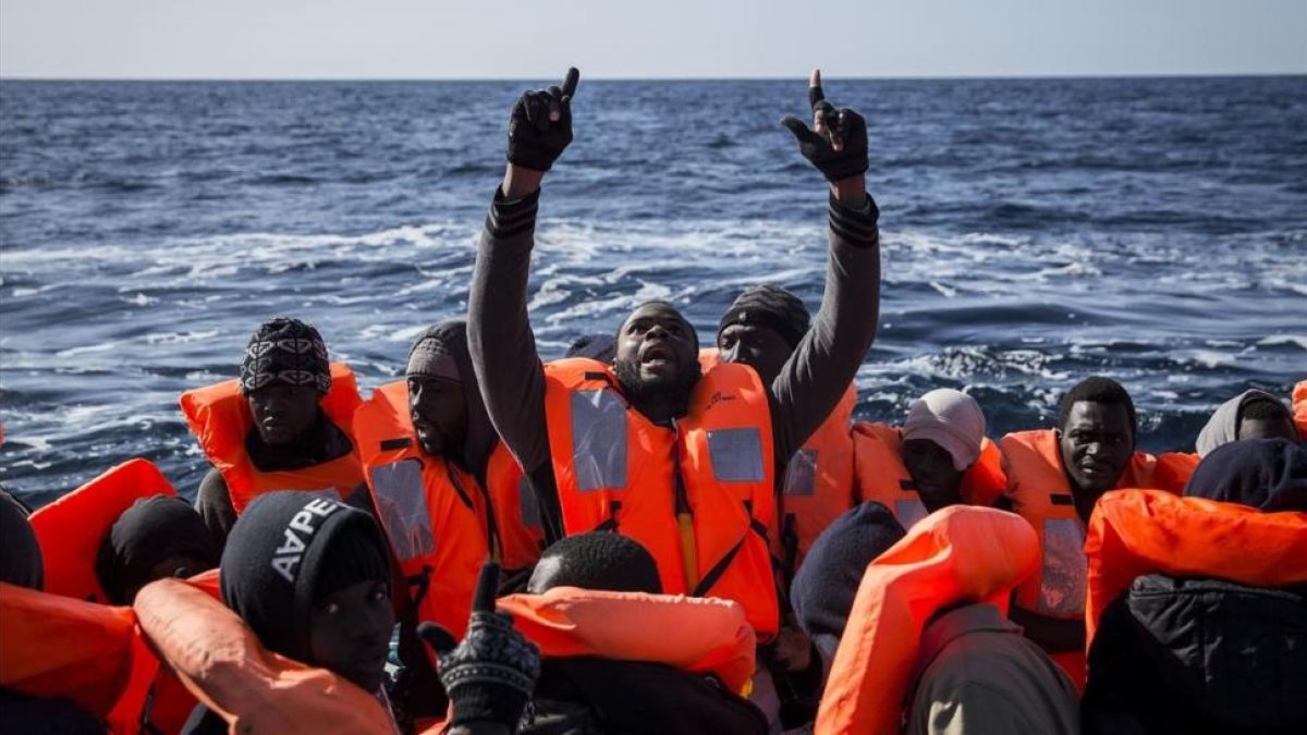 Inmigrantes subsaharianos reaccionan tras ser rescatados por integrantes de Proactiva Open Arms, en el Mediterráneo central, el 12 de enero del 2017.-AP / OLMO CALVO