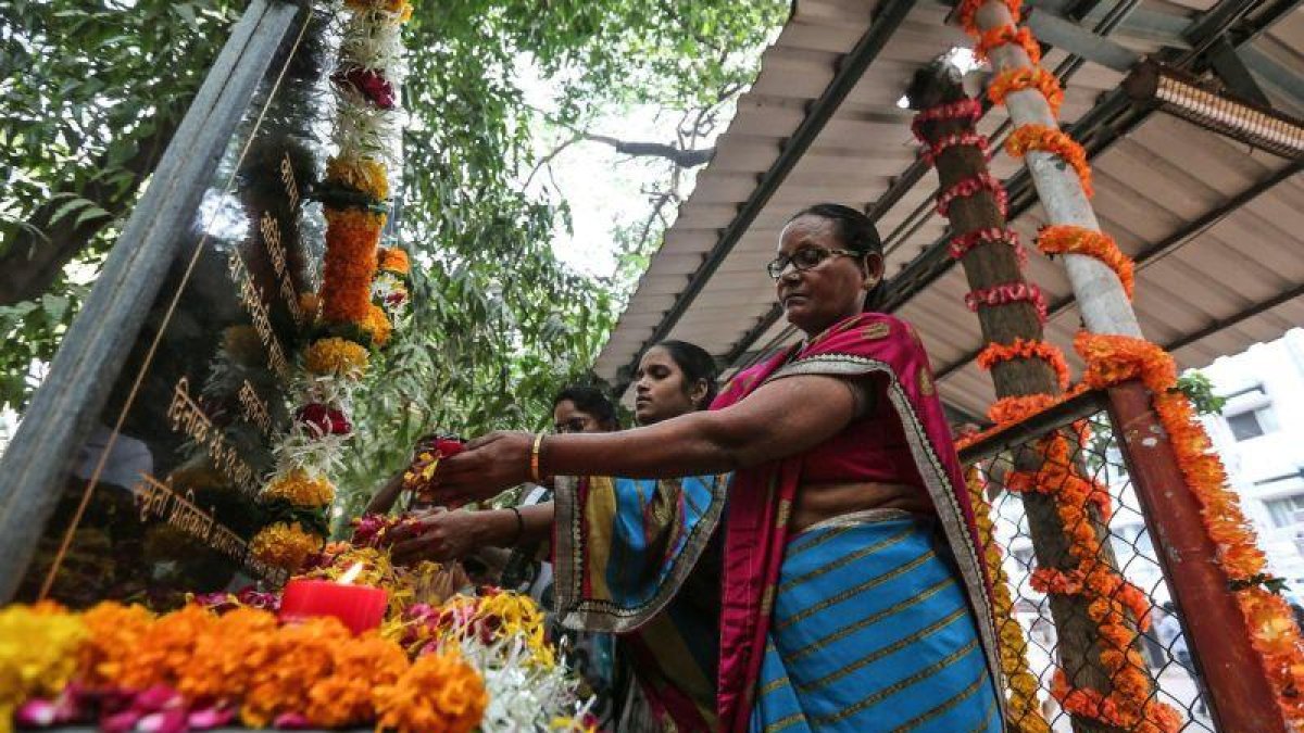 Mujeres rinden tributo  en el hospital de Cama  a las victimas de los atentados en Bombay de hace diez anos en los que insurgentes del grupo paquistani Lashkar-e-Taiba  LeT  mataron a tiros a 166 personas.-EFE / Divyakant Solanki
