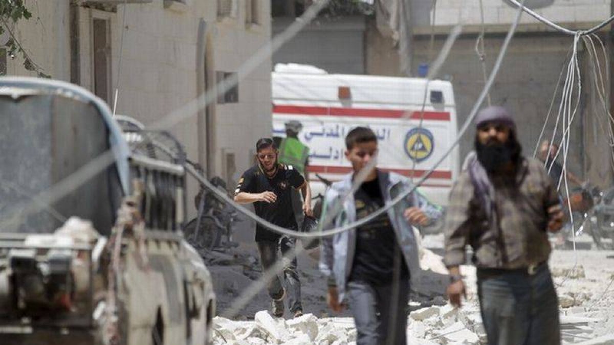 Un grupo de civiles junto al lugar donde ha estallado un barril lanzado por el régimen sirio.-Foto: REUTERS / KHALIL ASHAWI