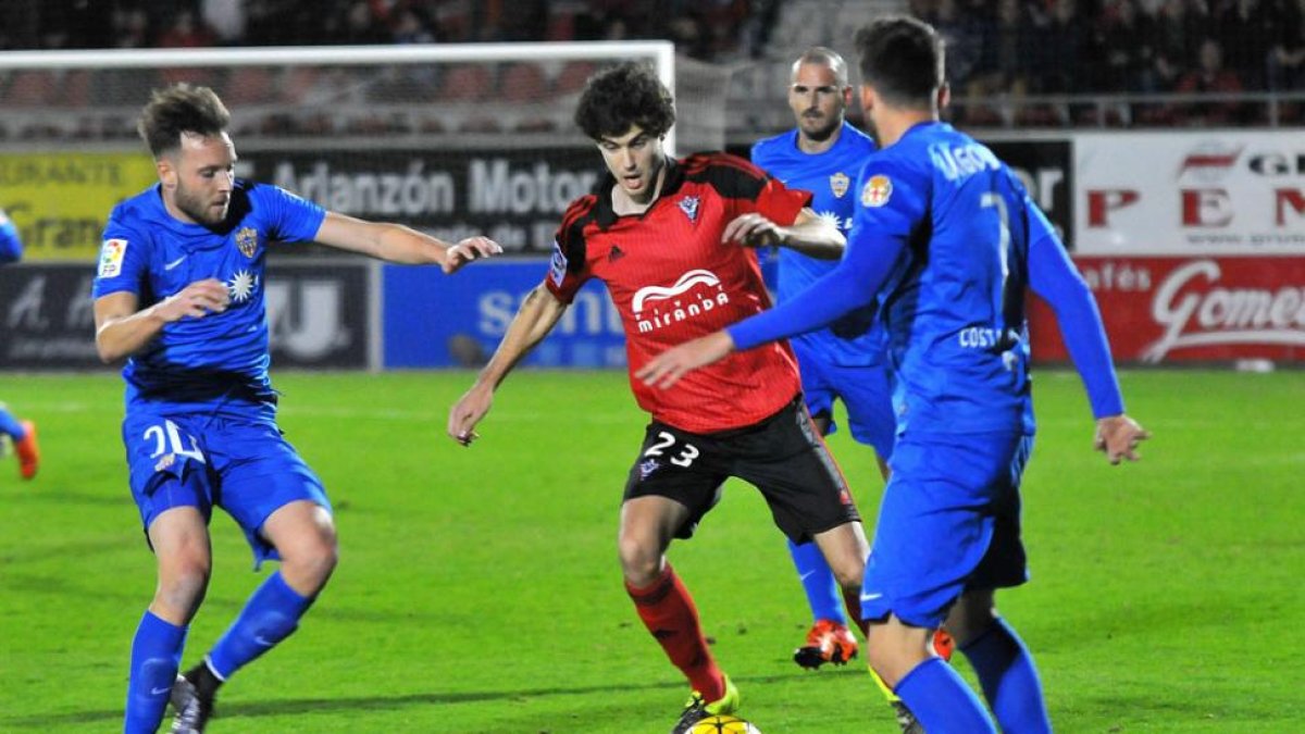 Néstor Salinas trata de zafarse del marcaje de dos jugadores del Almería en el último choque en Anduva-J. E. Egurrola