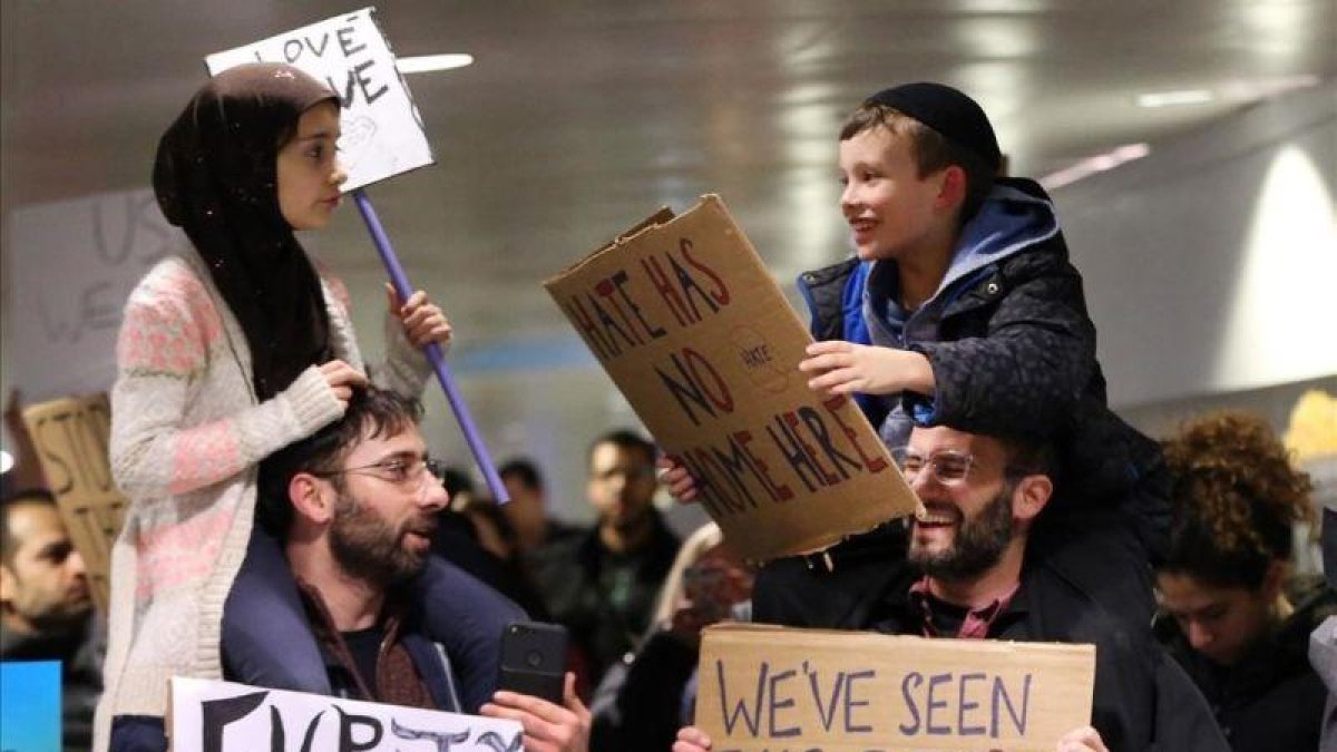 Adin y Meryem sentados sobre los hombros de sus padres, Jordan Bendant-Appell, un rabino, y Faith Yildrim, un musulmán, en una manifestación en Chicago.-Chicago Tribune