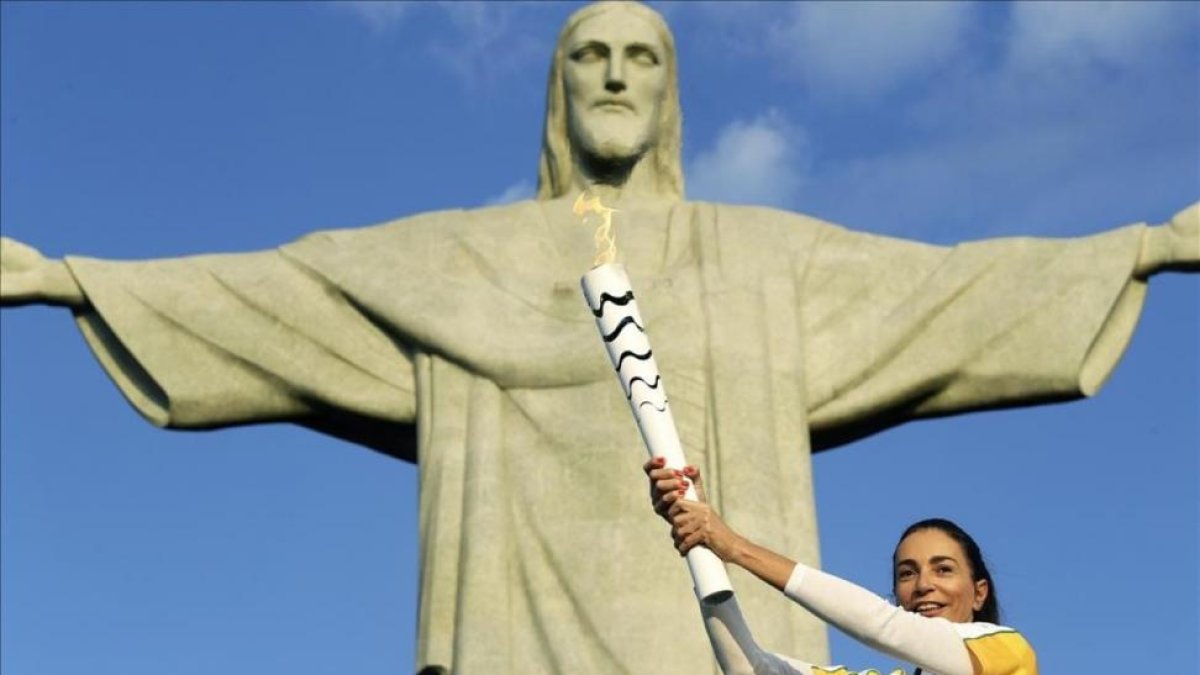 La exjugadora de voleibol brasileña Isabel Barroso, con la antorcha ante el Cristo Redentor de Corcovado.-EFE / FERNANDO MAIA