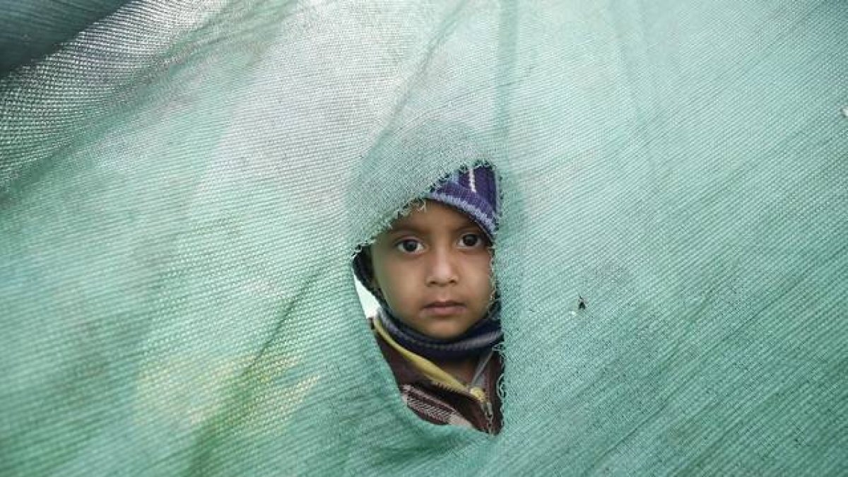 Una niña mira desde el agujero de una tienda en Katmandú, en el Nepal.-Foto: EFE / NARENDRA SHRESTHA