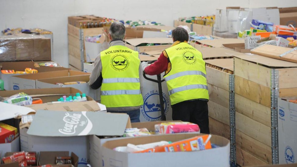 Dos voluntarios trabajan en la sede del Banco de Alimentos.-ISRAEL L. MURILLO