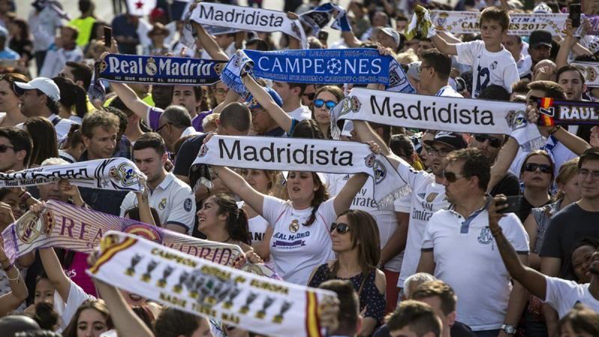 Aficionados del Real Madrid esperan la llegada del equipo madridista a la madrileña plaza de Cibeles, para celebrar el título conseguido de la Liga de Campeones en la final disputada ayer sábado frente a la Juventus en el estadio Millenium de Cardiff.-EFE
