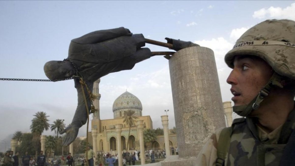 El marine Kirk Dalrymple mira como cae la estatua de Sadam Husein el día de la caída de Bagdad.-REUTERS / GORA TOMASEVIC
