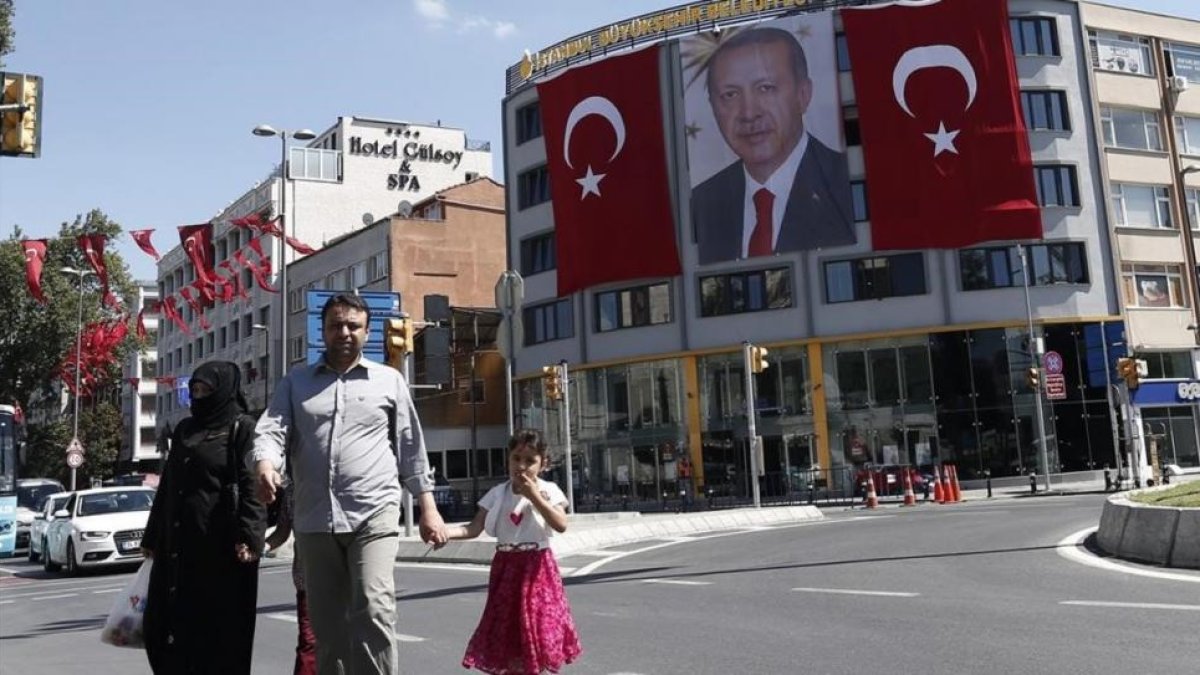 Vista general de una imagen gigantesca del presidente turco Recep Tayyip Erdogan, entre dos banderas del país, en Estambul, este jueves. Turquía se resiente como destino turístico de los españoles EFE / SEDAT SUNA Miembros de las unidades especiales turca-EFE / SEDAT SUNA
