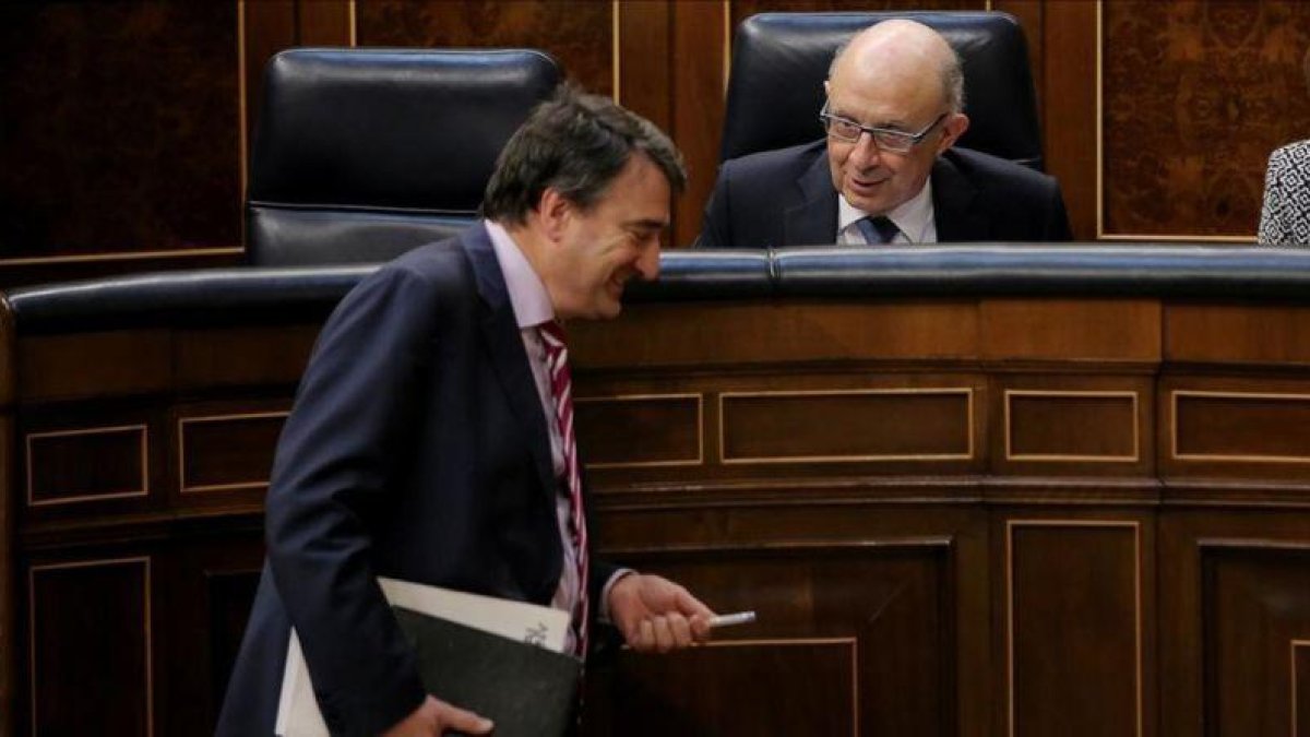 El portavoz del PNV, Aitor Esteban, bromea con el ministro de Hacienda, Cristóbal Montoro, este miércoles en el Congreso-JOSÉ LUIS ROCA