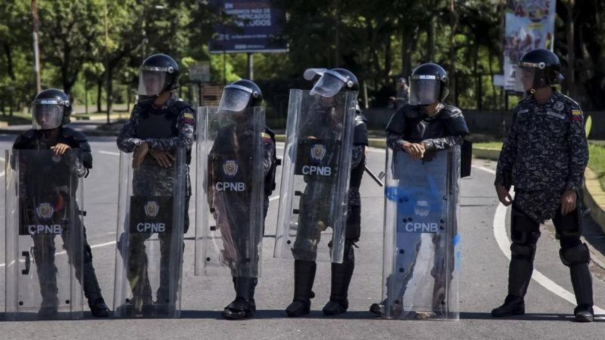 Integrantes del Cuerpo de Policía Nacional Bolivariana (CPNB) vigilan en una calle durante una manifestación de apoyo a un grupo de militares sublevados, el 6 de agosto.-EFE