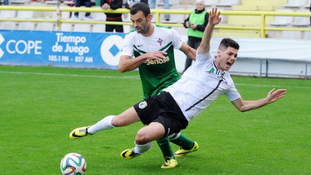 El delantero blanquinegro Cristian cae tras la entrada de un jugador del Racing de Ferrol.-ISRAEL L. MURILLO