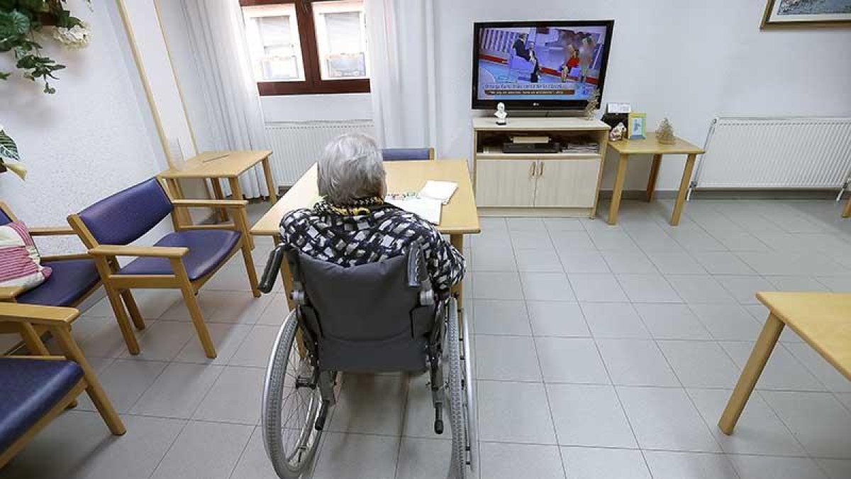 Una usuaria de una residencia de ancianos gestionada por la Diputación ve la televisión.-RAÚL G. OCHOA