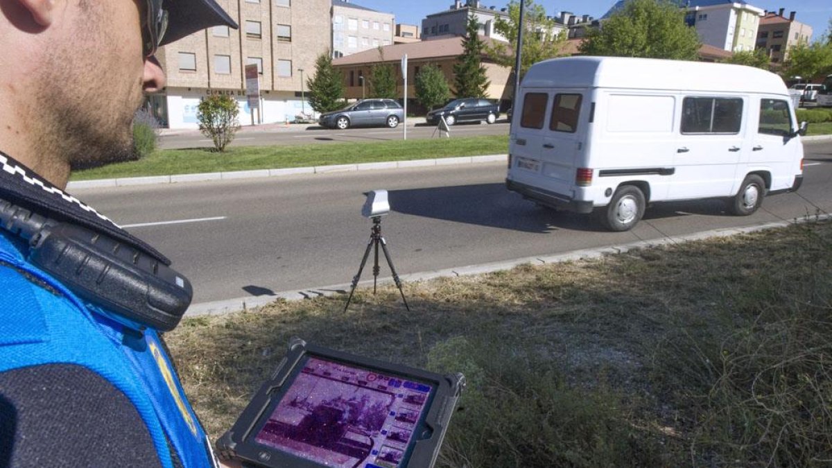 Un policía local controla la velocidad de un vehículo con el radar móvil.-ISRAEL L. MURILLO