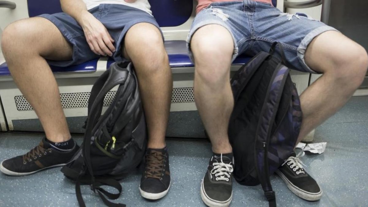 Dos viajeros del metro de Barcelona ocupan tres asientos con su 'despatarre'.-AUGUST BLÁZQUEZ