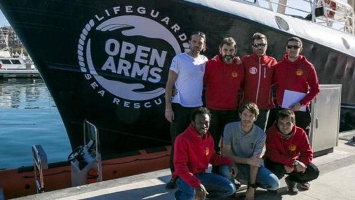 La tripulación integrada por miembros de la oenegé Open Arms junto al barco 'Golfo Azzurro' en el Port Vell de Barcelona.-JOAN CORTADELLAS