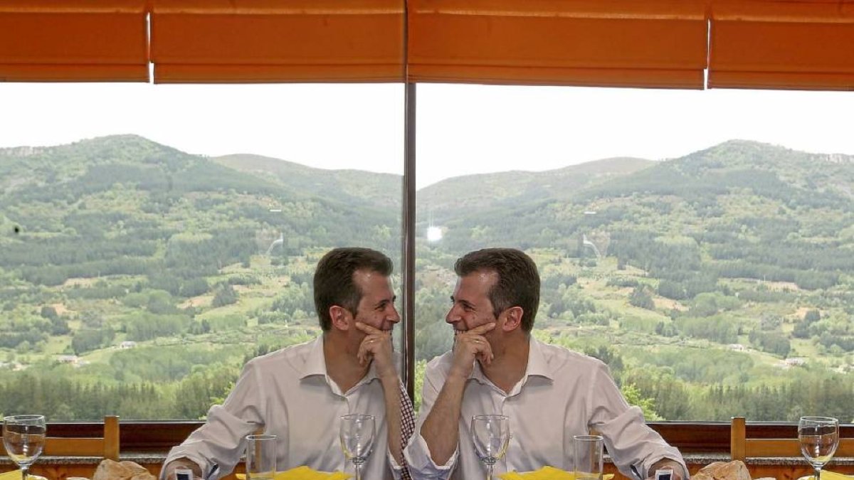 Luis Tudanca bromea con su reflejo en la mesa de un restaurante con Los Ancares al fondo en una comida con militantes en El Espino.-Ical