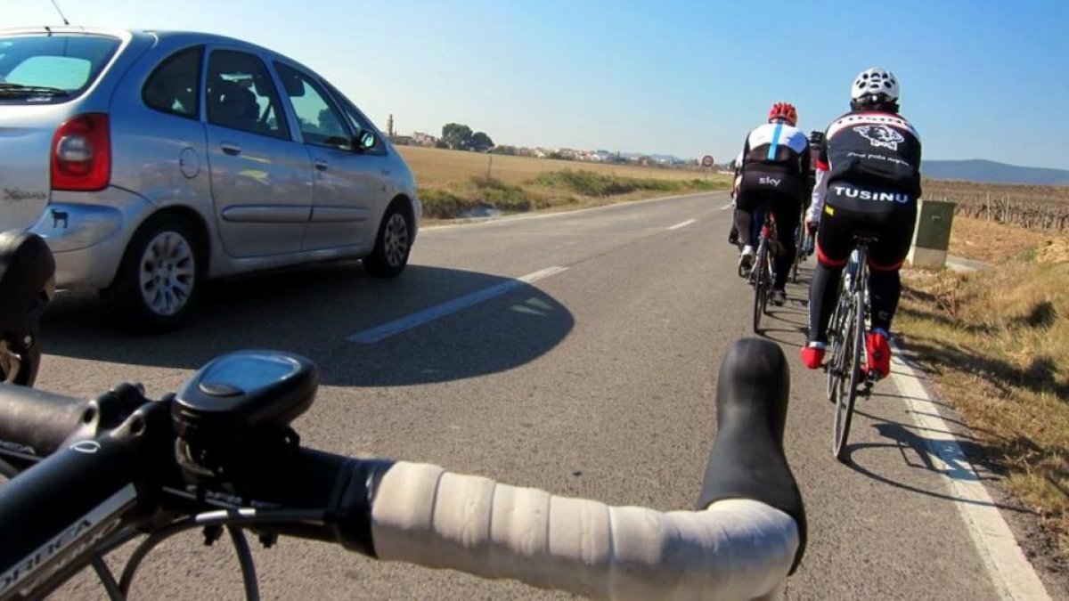 Dos ciclistas circulan por una carretera catalana.-ARCHIVO
