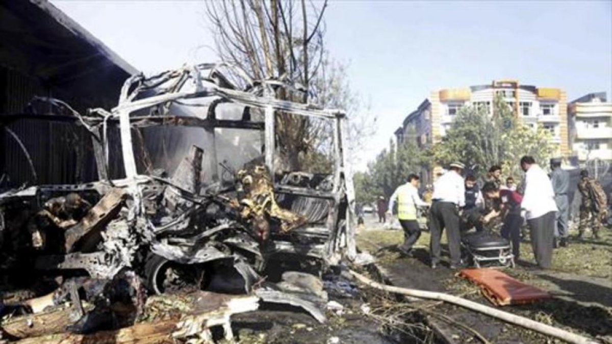 Rescate de víctimas entre los restos calcinados del autobús atacado en Kabul-EFE / HEDAYATULLAH AMID