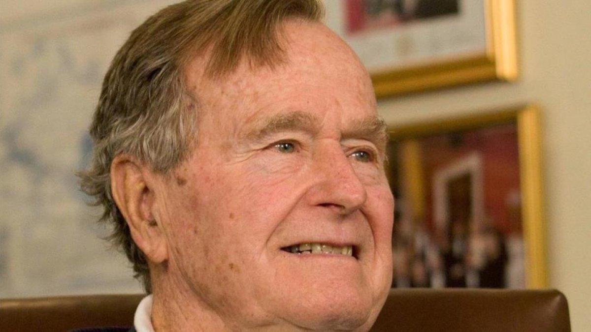 George H.W. Bush sonríe al escuchar al candidato presidencial republicano Mitt Romney, a quien apoyó en la elección del 2012, en un acto en Houston, el 29 de marzo del 2012.-REUTERS / DONNA CARSON