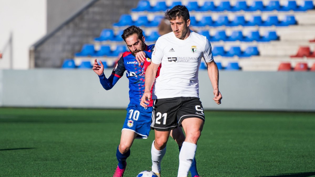 Saúl Berjón protege el balón ante la presión del jugador del Langreo Jorge Hernández. UP LANGREO