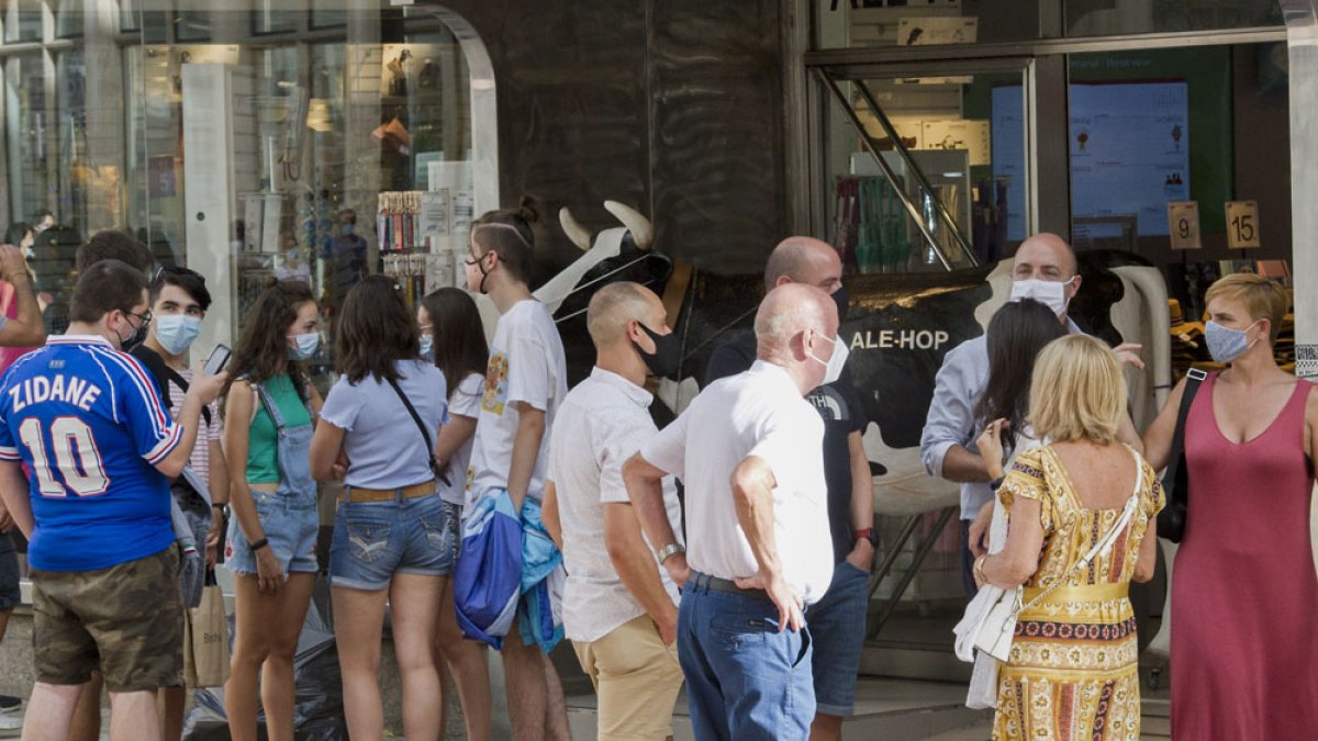 Varios grupos de personas ayer frente a un comercio del centro de Burgos. ISRAEL L. MURILLO
