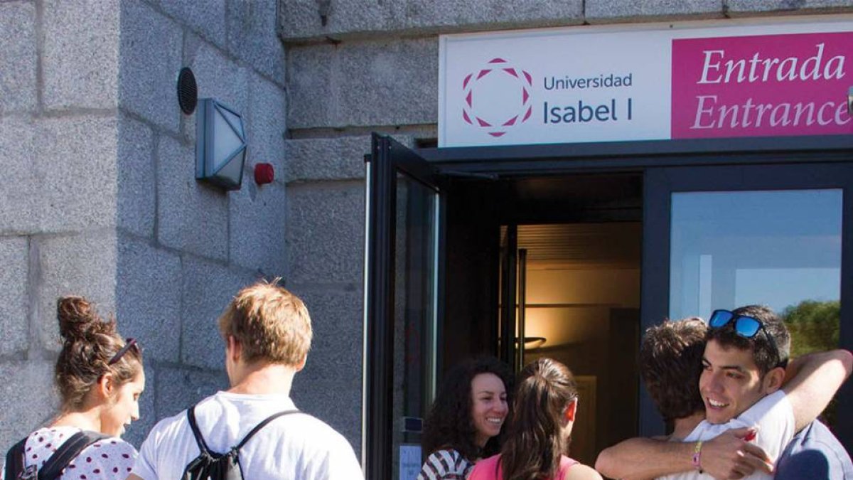 Un grupo de alumnos de la universidad se saludan en la entrada del edificio.-ECB