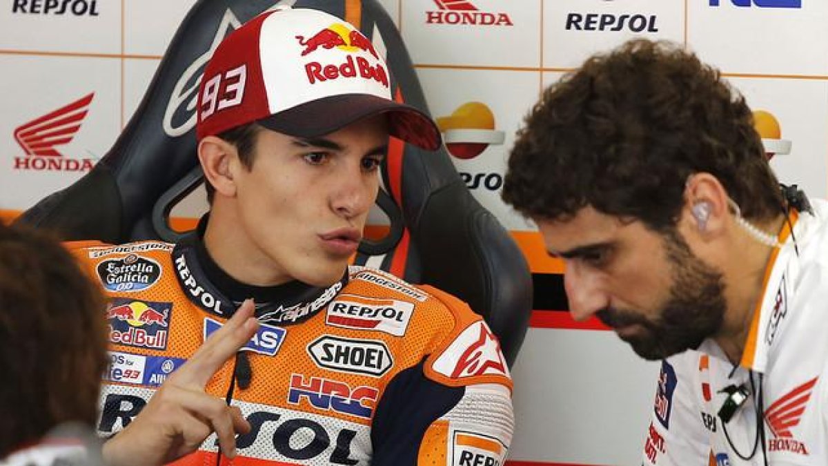 Marc Márquez conversa con un miembro de su equipo en el box de Repsol-Honda, en el circuito de Sepang.-AP / LAI SENG SIN