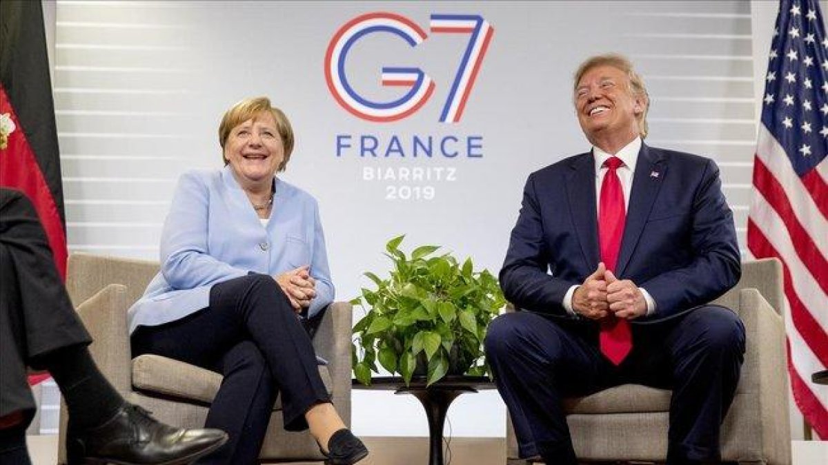 El presidente norteamericano Donald Trump y la cancillera alemana Angel Merkel se ríen durante la cumbre del G/ en Biarritz.-ANDREW HAMIK (AP)