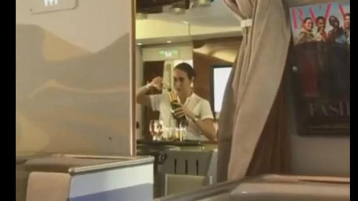 Captura del vídeo en el que se ve a la azafata de Emirates rellenando una botella de champán con restos de copas usadas.-YOUTUBE