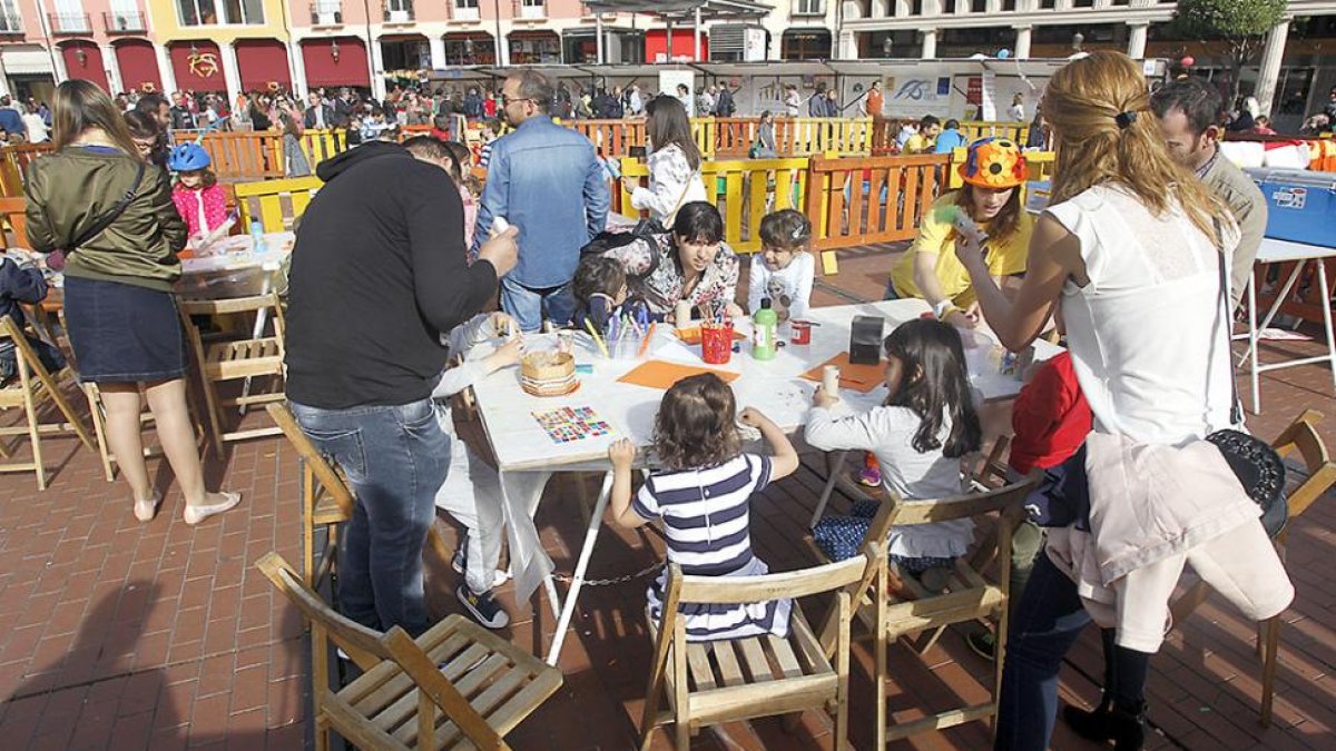 Varios niños y sus padres participan en los talleres organizados con motivo de la celebración.-SANTI OTERO