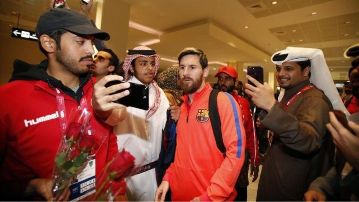 Aficionados catarís se hacen fotos con Messi en el aeropuerto de Doha.-FCB / MIGUEL RUIZ