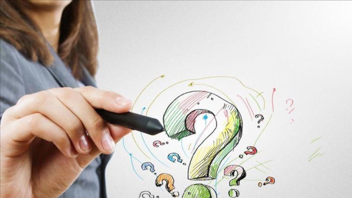 Una mujer dibuja un signo de interrogación.-123RF