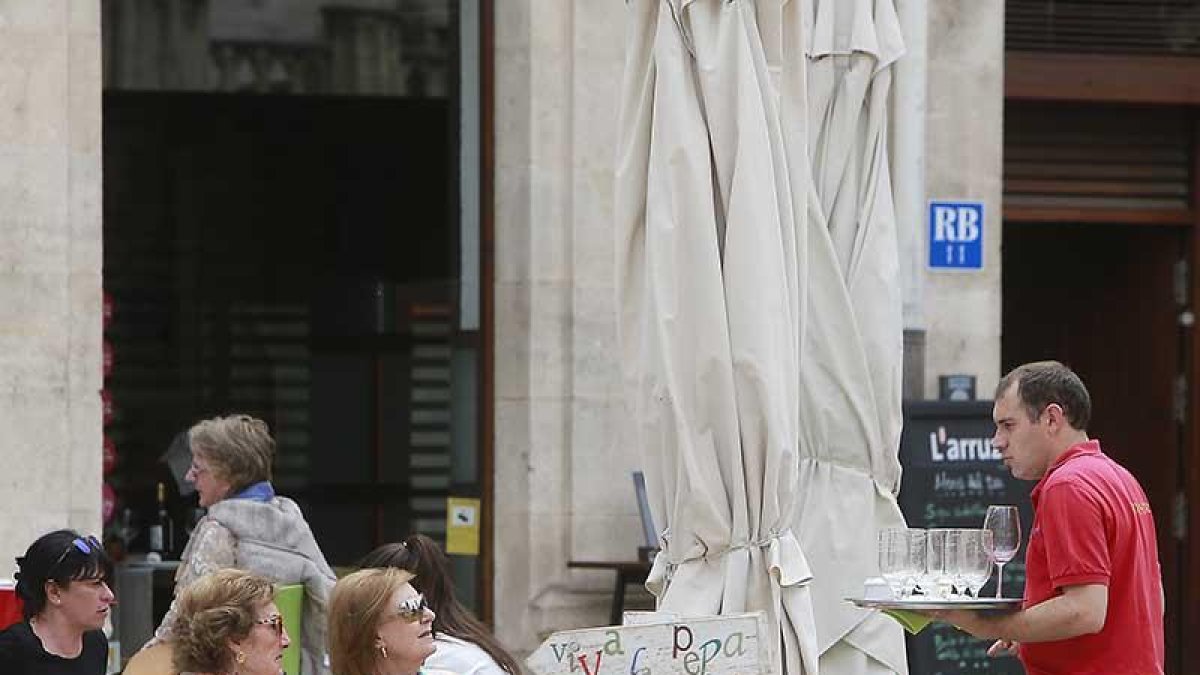 Un camarero atiende a dos mujeres en una terraza de la capital burgalesa.-RAÚL G. OCHOA