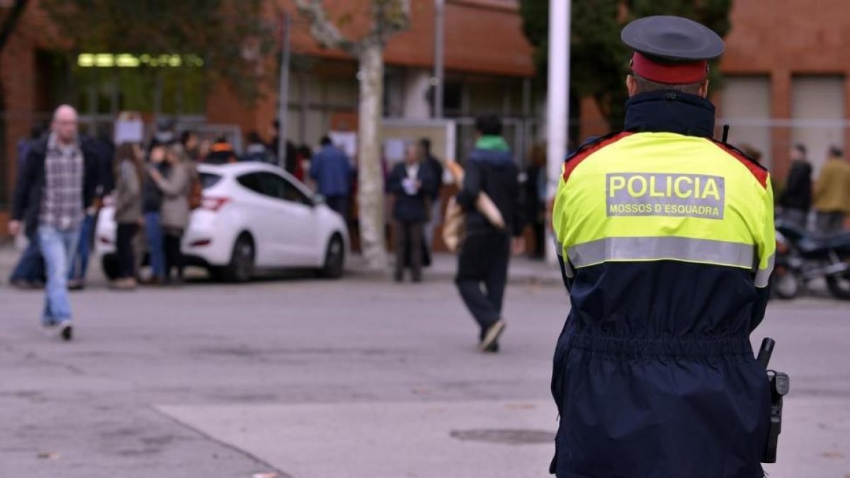 Un agente de los Mossos ante el IES Icària durante la consulta del 9-N-XAVIER JUBIERRE