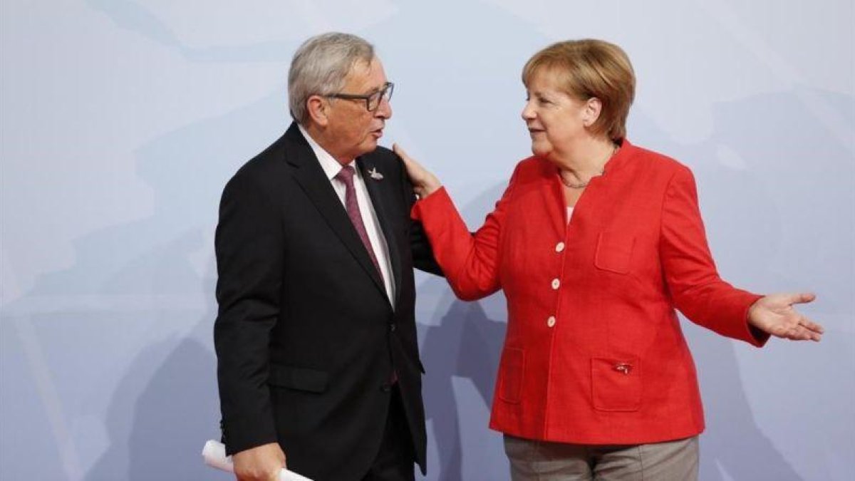 Jean Claude Juncker y Angela Merkel, en la cumbre del G-20 del pasado mes de julio en Hamburgo.-FRIEDEMANN VOGEL POOL