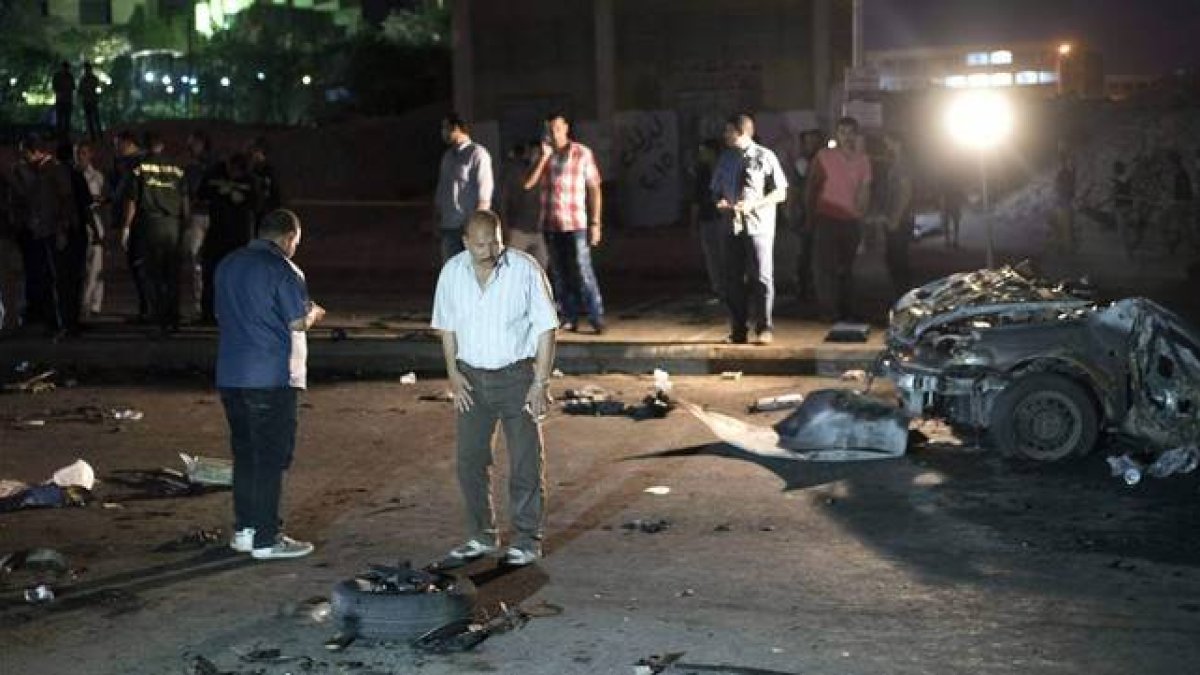Oficiales de seguridad inspeccionan los restos de un coche bomba que estalló este martes en un distrito de Guiza, vecina de El Cairo.-Foto: EFE / MOHAMED HESHAM