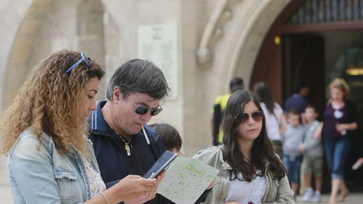 Una familia de turistas contempla el plano de la ciudad junto a la Catedral de Burgos.-RAÚL G. OCHOA