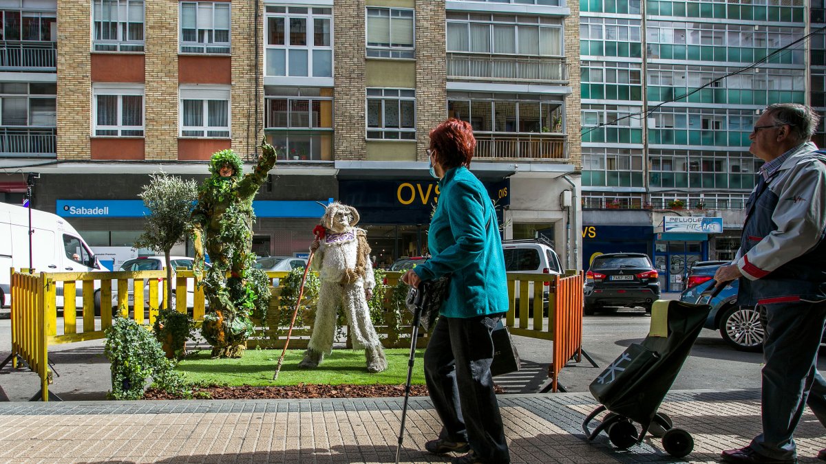 Unos viandantes observan el jardín improvisado en la calle Francisco Grandmontagne, de Gamonal. TOMÁS ALONSO